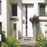 Moderne weiße Hausfassade mit Garten, Biffar Projekt, hochwertige Bau- und Renovierungsarbeiten.