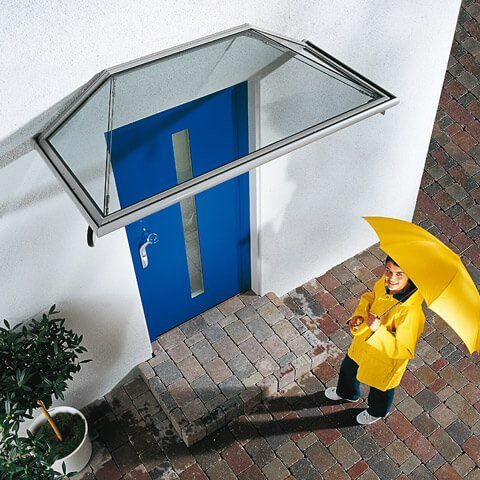 Modernes Gebäude mit blauer Tür und Glasüberdachung, optimiert für effizientes Design.