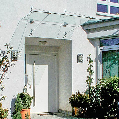 Eingangsbereich eines modernen Hauses mit minimalistischer Tür und begrüntem Eingangsbereich.