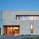 Moderne Betonarchitektur mit großen Fenstern und minimalistischer Gestaltung.