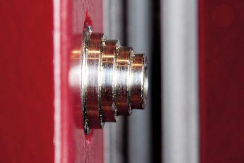 Hochwertiger Metallbolzen an einer roten Tür für Sicherheit und Stabilität.