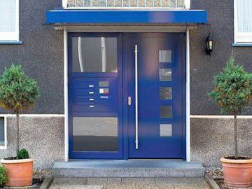 Hauseingang mit blauer Tür und modernen Design-Elementen, ideal für hochwertige Immobilien.