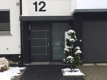 Hauseingang mit blauer Tür und modernen Design-Elementen, ideal für hochwertige Immobilien.
