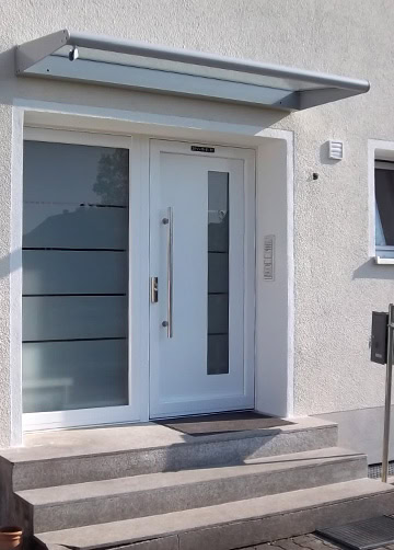 Eingangstür mit modernem Design und Glasdetails, barrierefreier Zugang, ideal für Wohnhäuser.