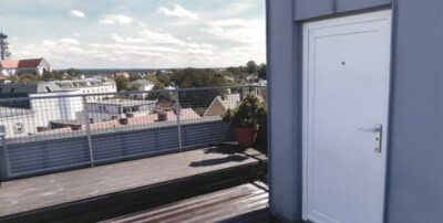 Dachterrasse mit Stadtblick und Zugangstür, modernes Design, ideal für private oder gewerbliche Nutz.