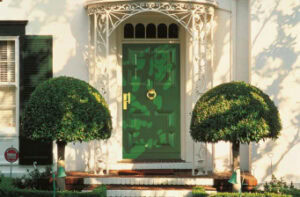 Elegante grüne Haustür mit stilvoller Dekoration und gepflegtem Eingangsbereich.