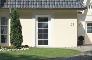 Helles Haus mit moderner Eingangstür und gepflegtem Garten in Deutschland.