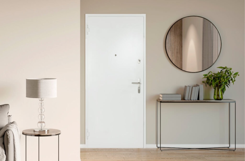 Moderner Flur mit weißer Tür und dekorativem Spiegel, freundliche Wohnatmosphäre, stilvoller Eingangsbereich.